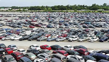 Wide view of a crowded auto auction lot packed with parked vehicles
