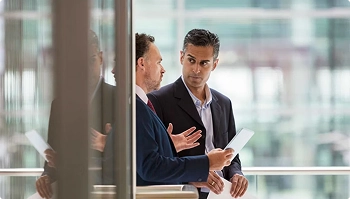 Two business professionals discussing transport logistics in a modern office