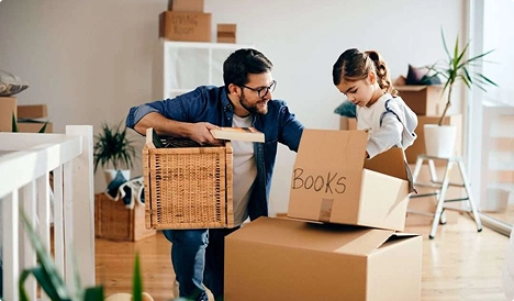 father and daughter packing moving boxes at home for relocation