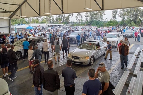 busy auto auction lane with dealers and cars moving through for wholesale vehicle transport