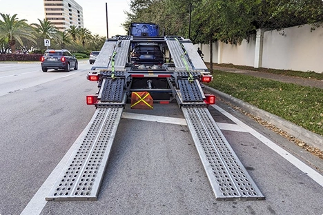 car hauler trailer with ramps down on city street ready for vehicle loading