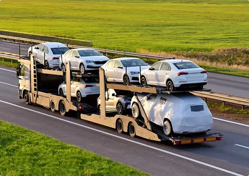 multi level car hauler driving on highway transporting several vehicles across long distance