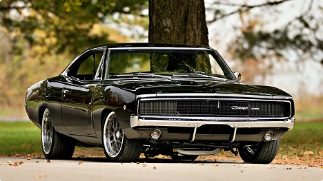 black classic muscle car parked under a tree in autumn representing classic car shipping