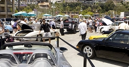 outdoor car meet with classic and sports cars displayed in bright sunny weather