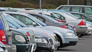 row of parked vehicles in a lot ready for dealership pickup