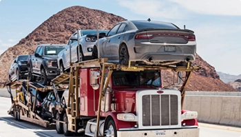 open car carrier semi hauling multiple vehicles on a desert highway
