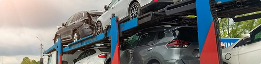 open car carrier loaded with suvs and sedans during pickup for transport