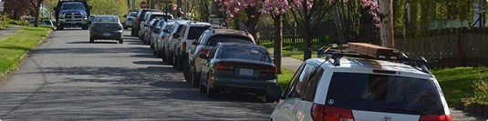 row of parked cars along a residential street ready for pickup and delivery