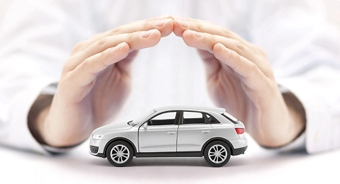 hands covering a car model representing auto transport insurance coverage