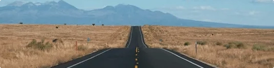 long open highway toward mountains showing route distance factor