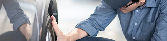 technician inspecting a car door for non running or oversized vehicle notes