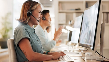 customer service agent smiling while assisting clients through headset