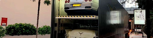 enclosed double deck trailer transporting luxury and classic cars