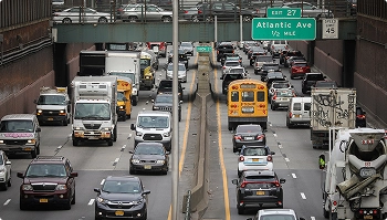 busy highway traffic with cars trucks and school bus near atlantic avenue exit