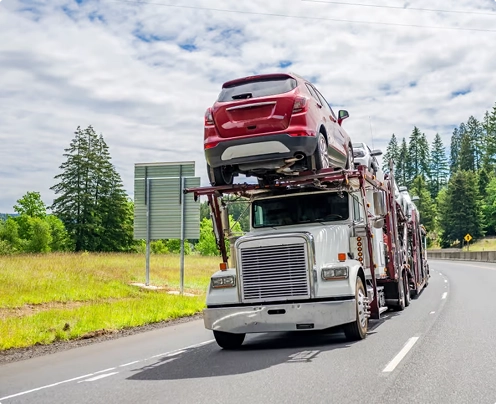 open car carrier transporting a red SUV on a highway