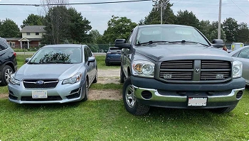 parked sedan and pickup truck side by side showing vehicle size difference