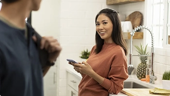 woman texting to coordinate car pickup at home