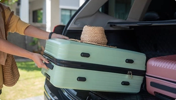person loading suitcases into suv trunk for seasonal move and car transport