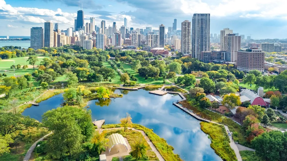 Aerial view of Chicago skyline overlooking Lincoln Park with green landscapes, ponds, and surrounding neighborhoods in daylight
