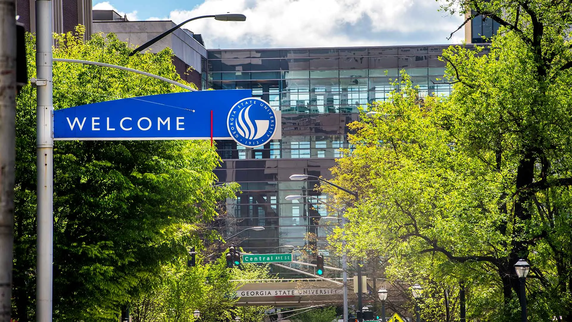 welcome sign displayed along a downtown arizona city street with buildings and trees