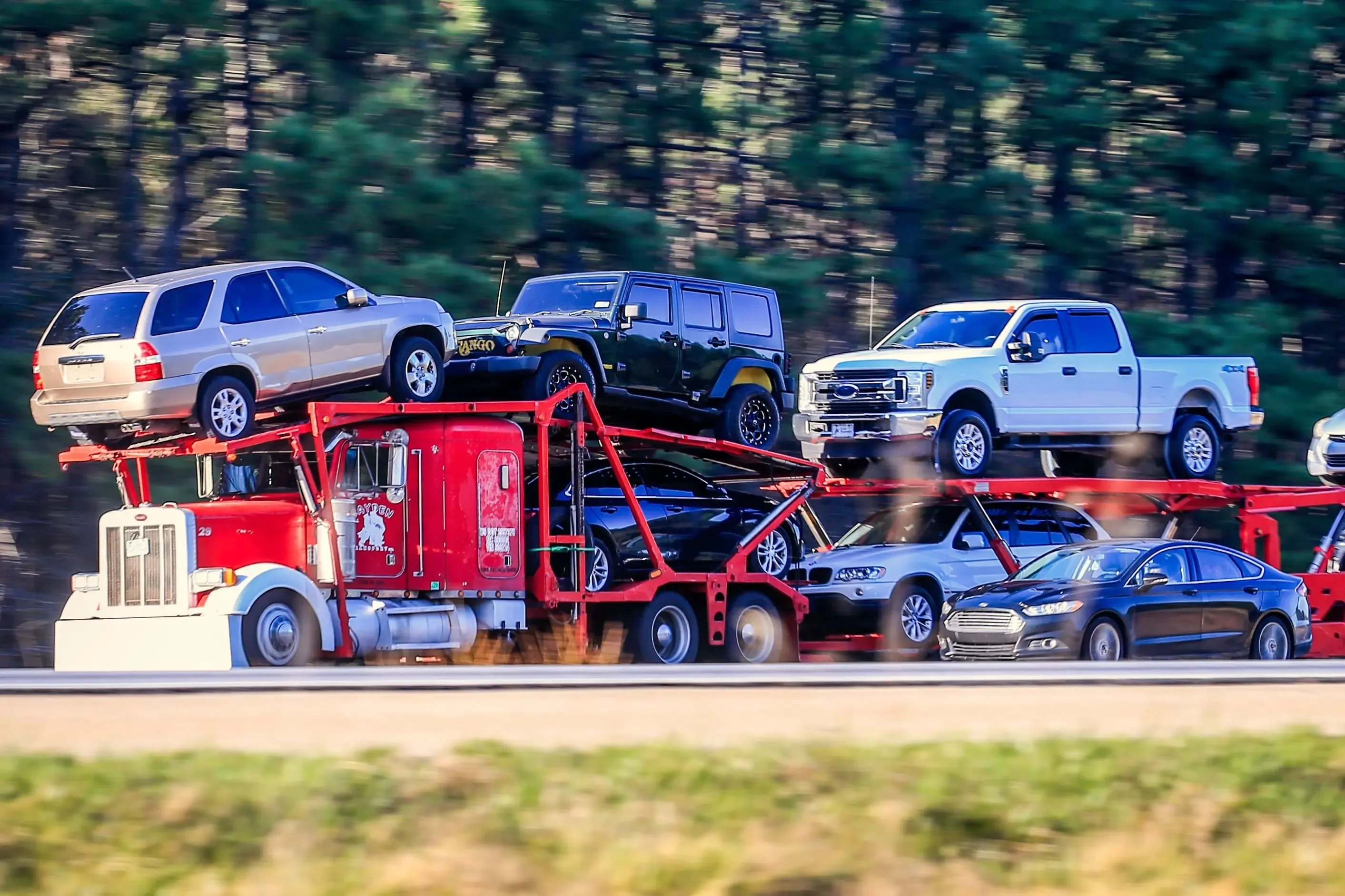 open-car-carrier-hauling-suvs-pickups-sedans-highway