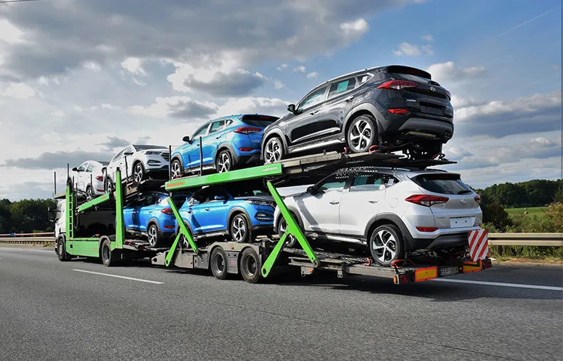 open car carrier transporting multiple vehicles on a highway during auto transport shipment