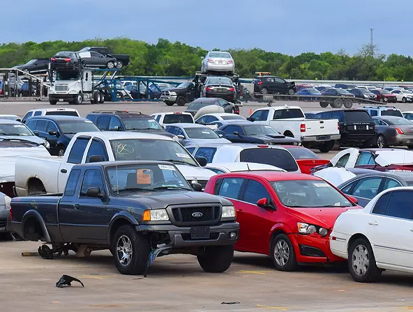 Auto auction lot filled with parked cars and trucks awaiting transport and sale