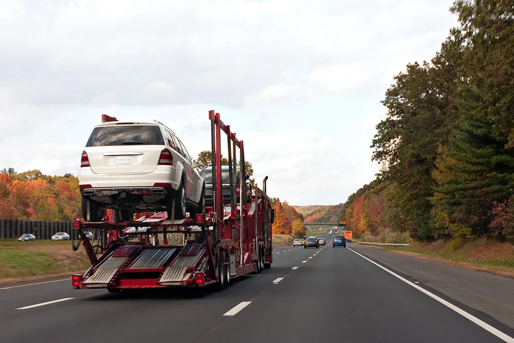 open-car-carrier-on-highway-in-fall-season