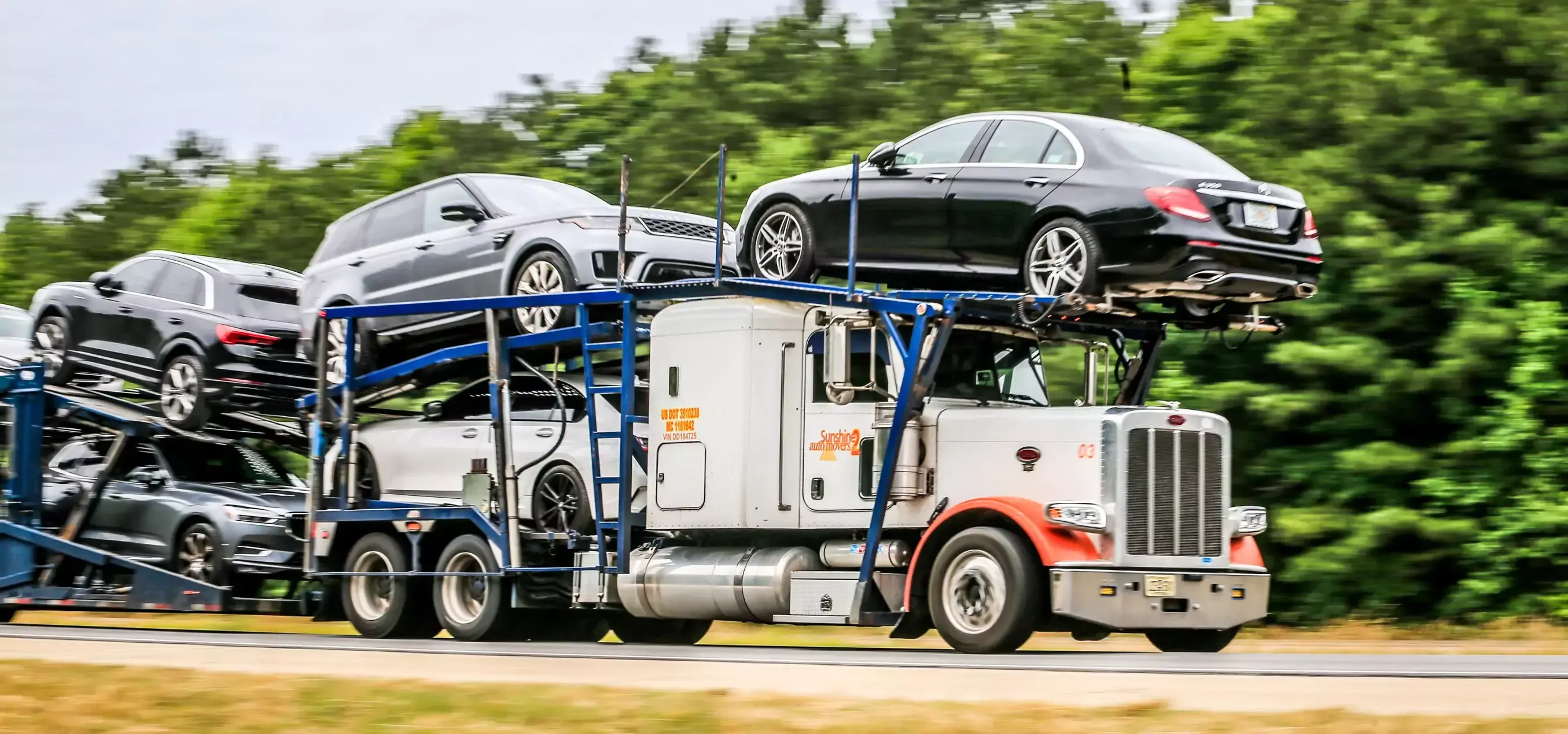 Auto transport truck hauling multiple cars on an open carrier for nationwide vehicle shipping services