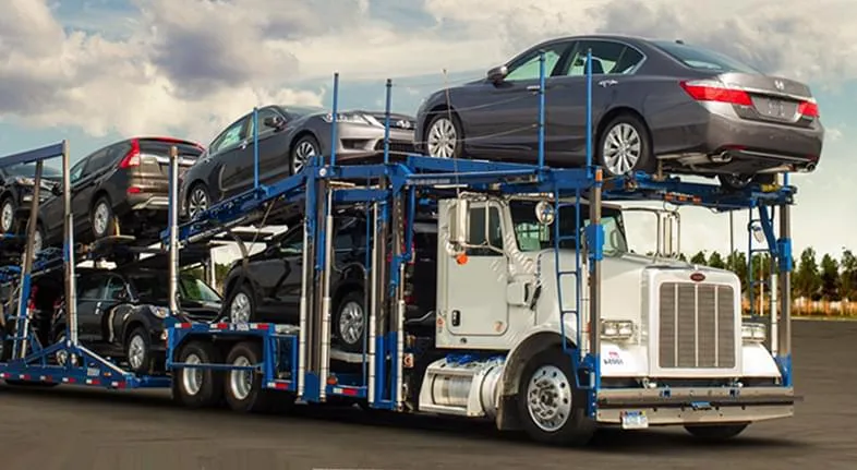 Open car transport truck carrying multiple vehicles on a multi car carrier for long distance auto shipping