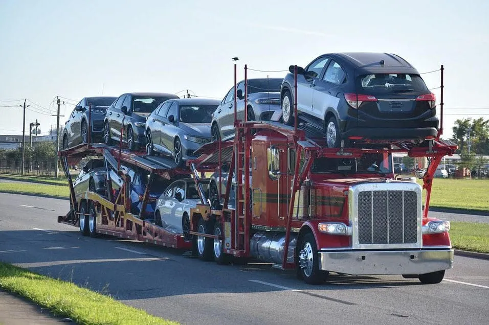 multi-car-auto-transport-trailer-hauling-multiple-sedans-and-suvs-on-a-highway-for-long-distance-vehicle-shipping