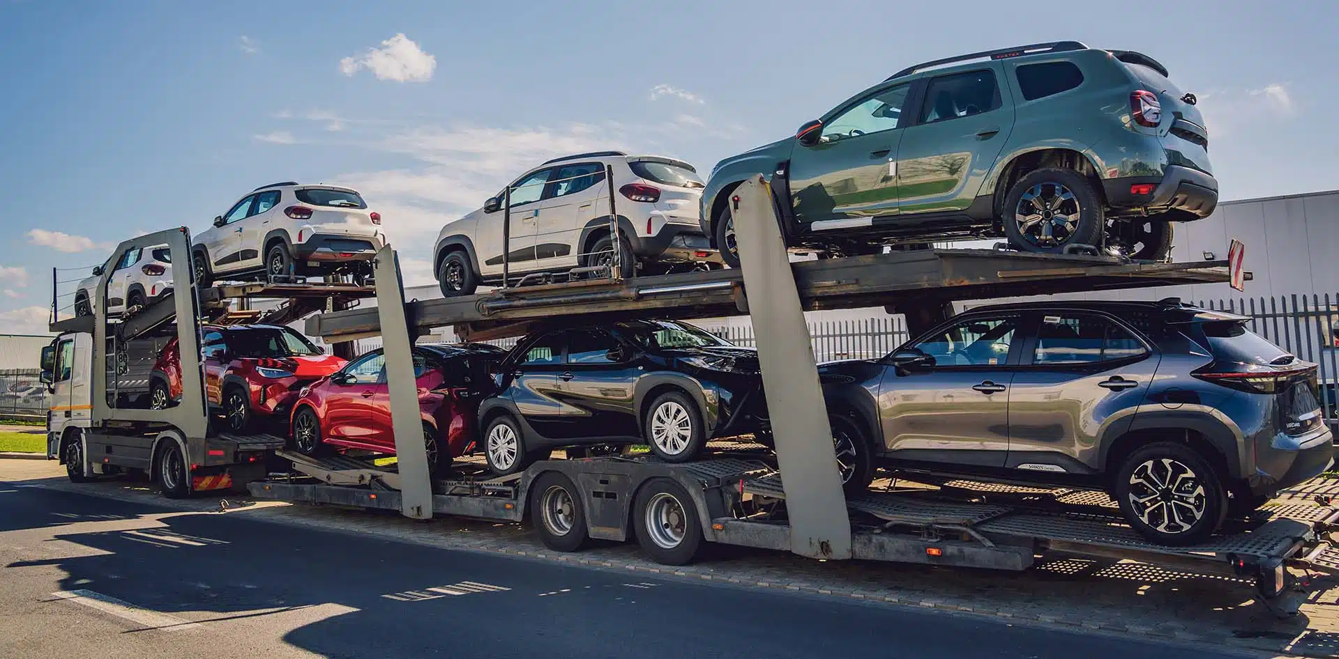 Multi car auto transport trailer loaded with SUVs and sedans being shipped nationwide by a professional vehicle carrier