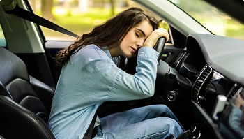 student resting in driver seat choosing car shipping instead of long drive